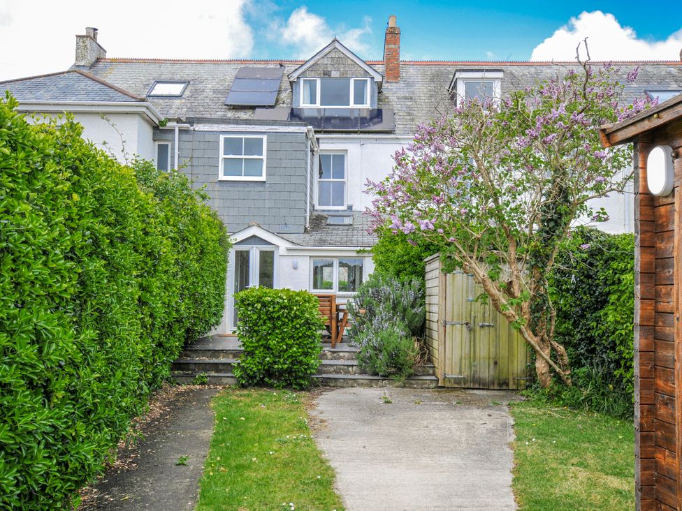 A garden with a house and seating area at 2 Glyddins 1910 in Rock