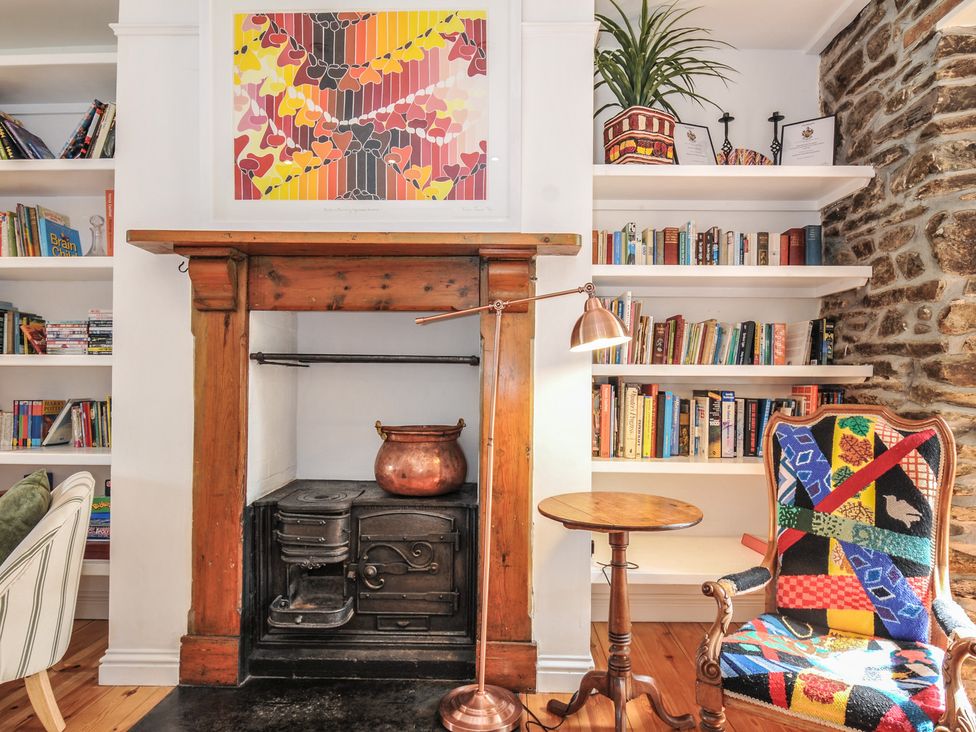 A living room with a fireplace and bookshelves at 2 Glyddins 1910 in Rock