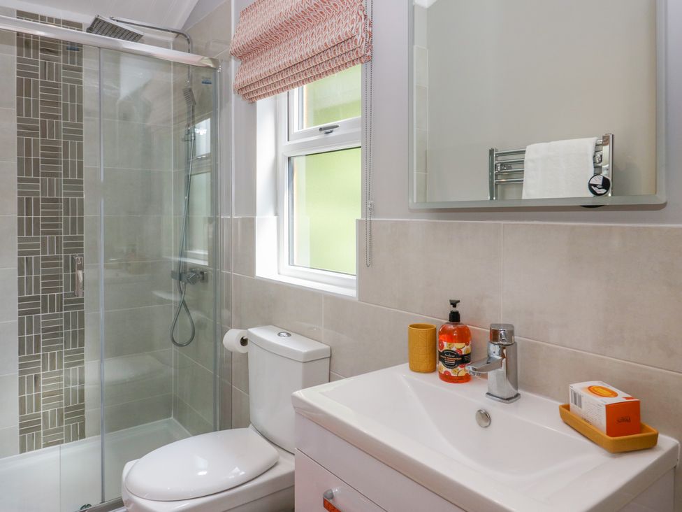 A bathroom with a toilet sink shower area and window at Waterside Lodge 55A Bowness White Cross Bay near Windermere