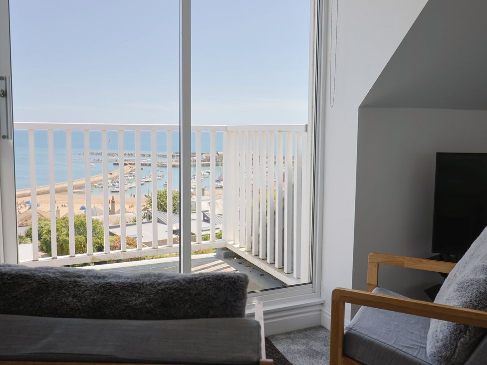 A living room with ocean view and balcony at 3 Harbour Heights Lyme Regis