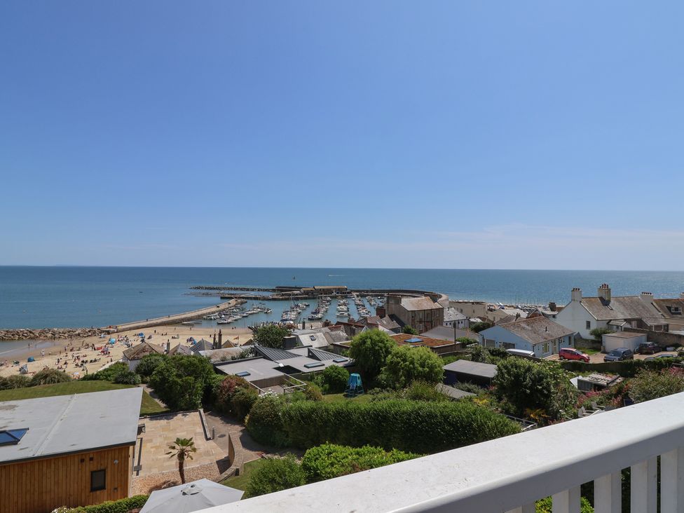 A view of a beach and sea with boats and houses at 3 Harbour Heights in Lyme Regis