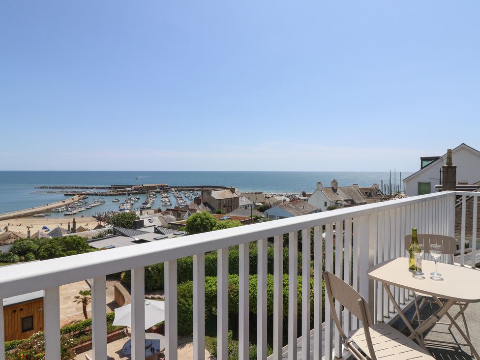 A balcony view overlooking the ocean and harbor at 3 Harbour Heights Lyme Regis
