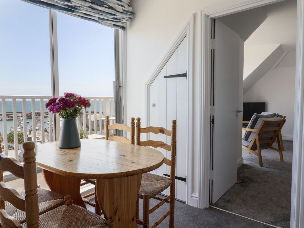 A dining room with a table and chairs at 3 Harbour Heights Lyme Regis