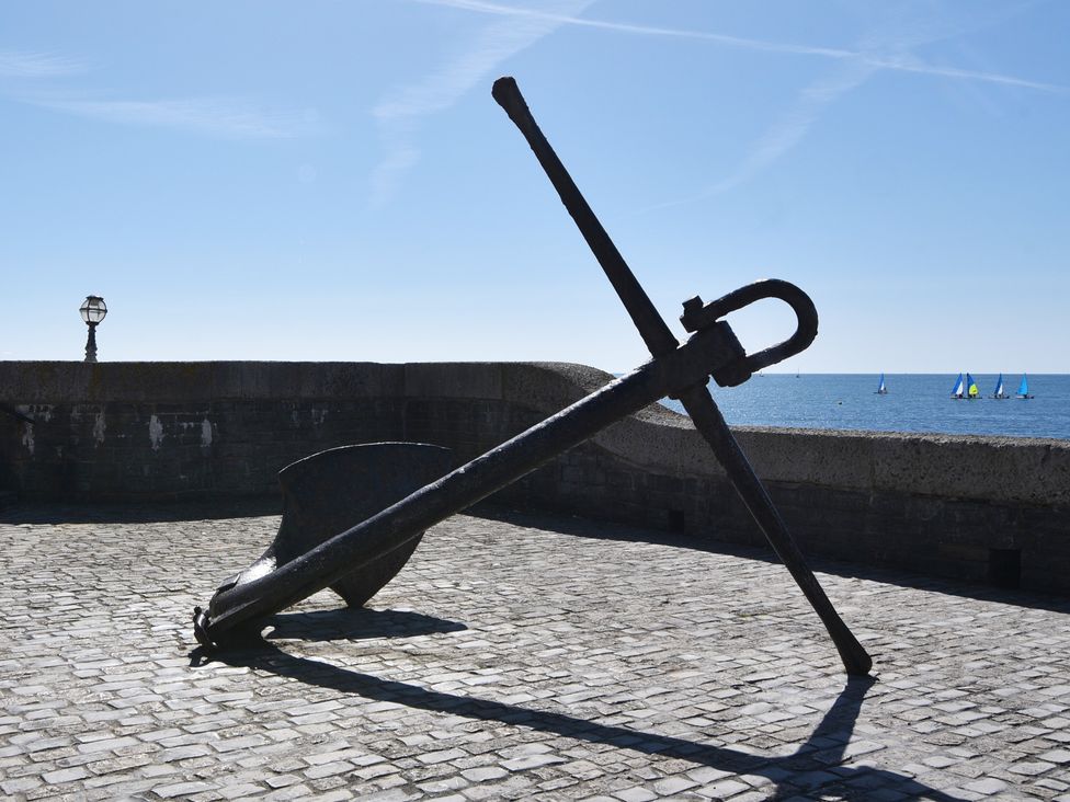 An anchor on cobblestone near the sea with boats at 3 Harbour Heights Lyme Regis