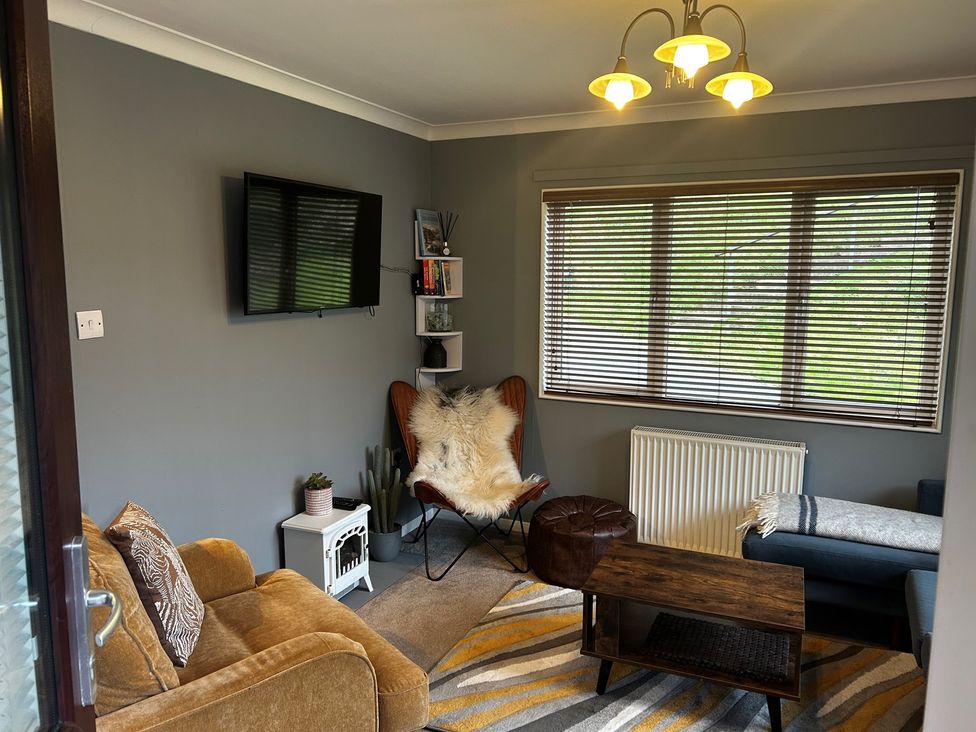 A snug with a television and seating at 22 Two Little Ducks in Lynton