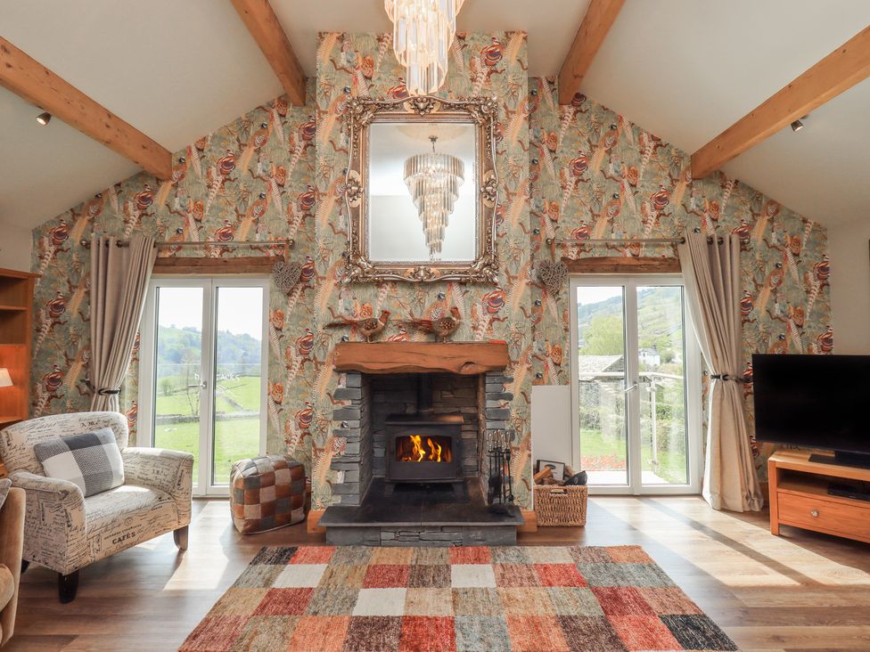 A living room with a fireplace and a sofa at Haystacks in Troutbeck