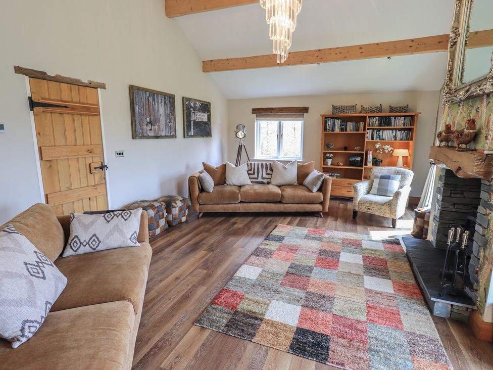 A living room with a sofa and bookshelf at Haystacks in Troutbeck
