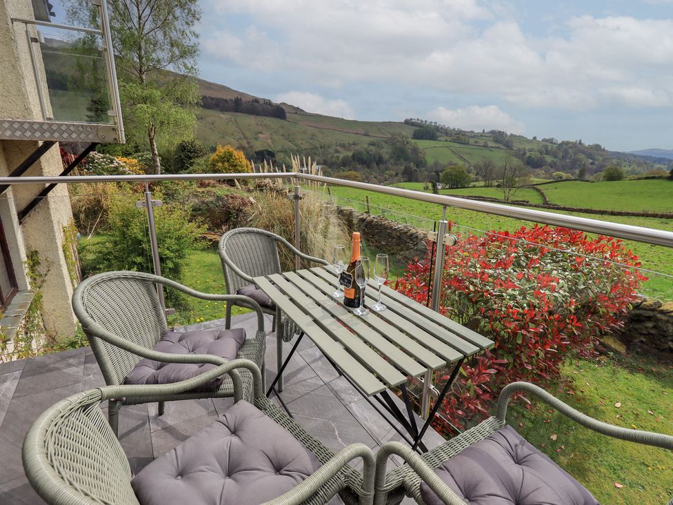 An outdoor seating area with a table and chairs at Haystacks in Troutbeck