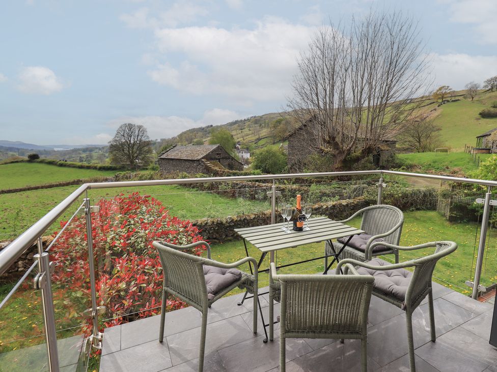 A balcony with chairs and a table at Haystacks in Troutbeck