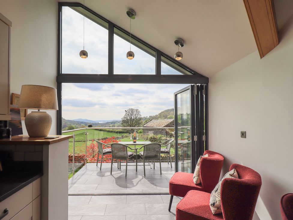 A conservatory with chairs and a table overlooking the garden at Haystacks in Troutbeck