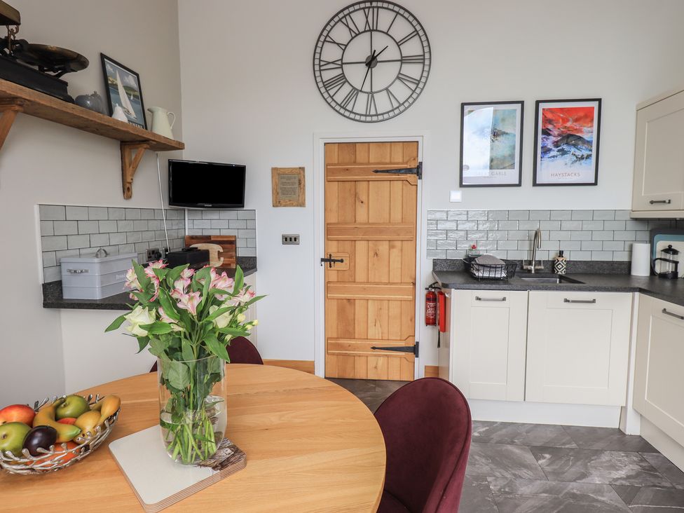 A kitchen with table and flowers at Haystacks in Troutbeck