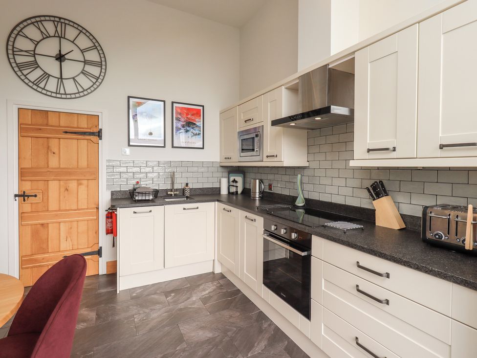 A kitchen with appliances and a door at Haystacks in Troutbeck