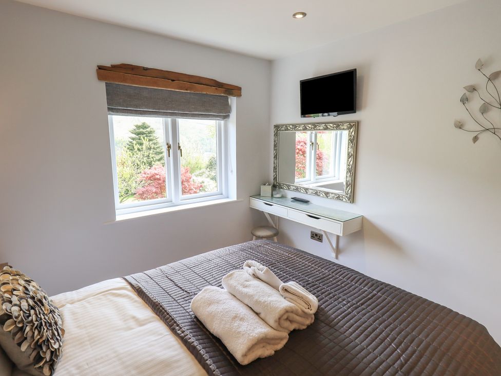 A bedroom with a bed and a mirror at Haystacks in Troutbeck