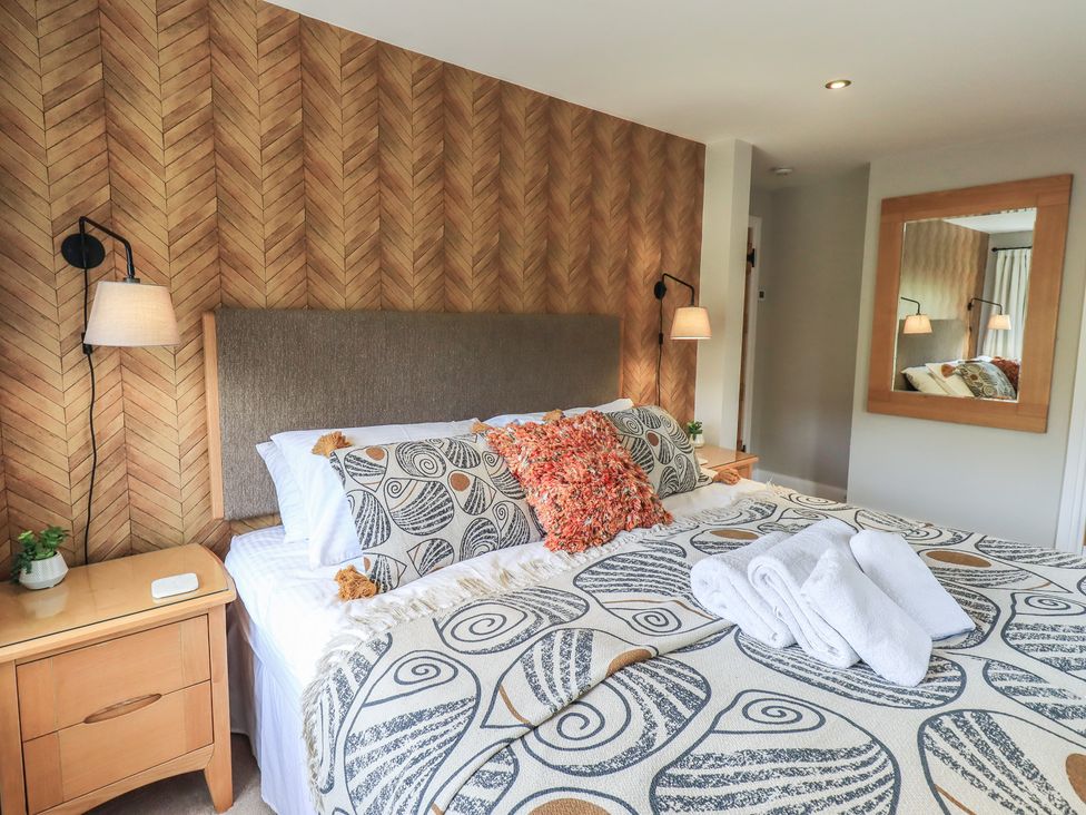 A bedroom with a bed and nightstand at Haystacks in Troutbeck