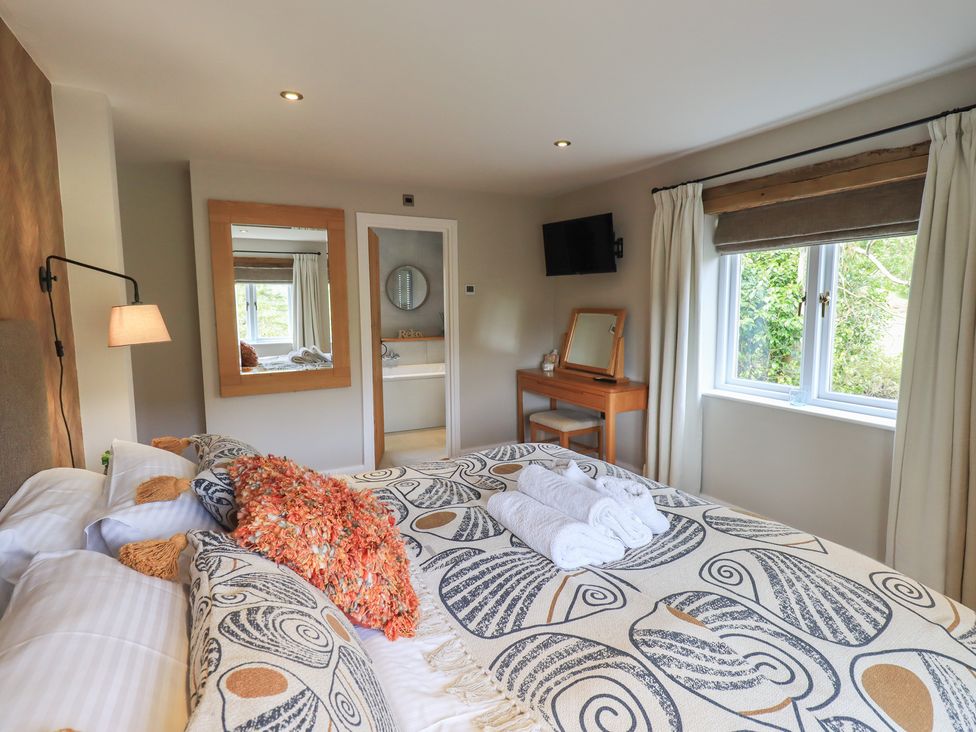 A bedroom with a bed and mirror at Haystacks in Troutbeck
