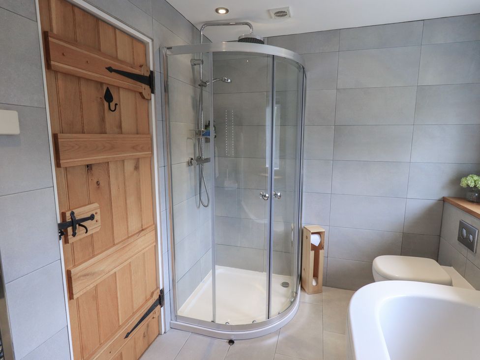 A bathroom with a shower, bathtub, and toilet at Haystacks in Troutbeck