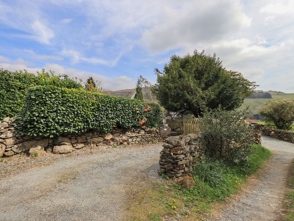 An outdoor area with a gravel path and stone wall at Haystacks in Troutbeck