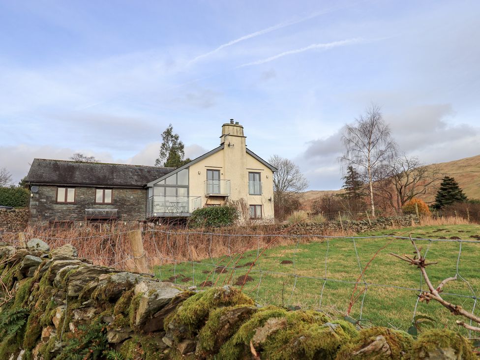 A house with a chimney and surrounding greenery at Haystacks in Troutbeck