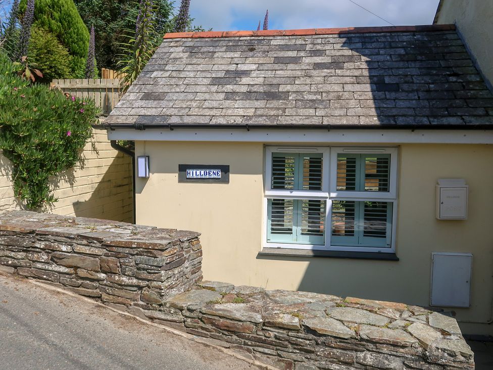 An exterior view of a house with a sign and stone wall at Hilldene in Treknow
