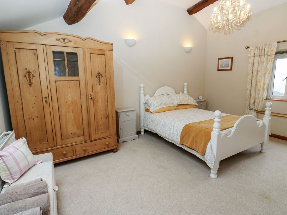A bedroom with a wardrobe and bed at Barley Cote Farm in Riddlesden