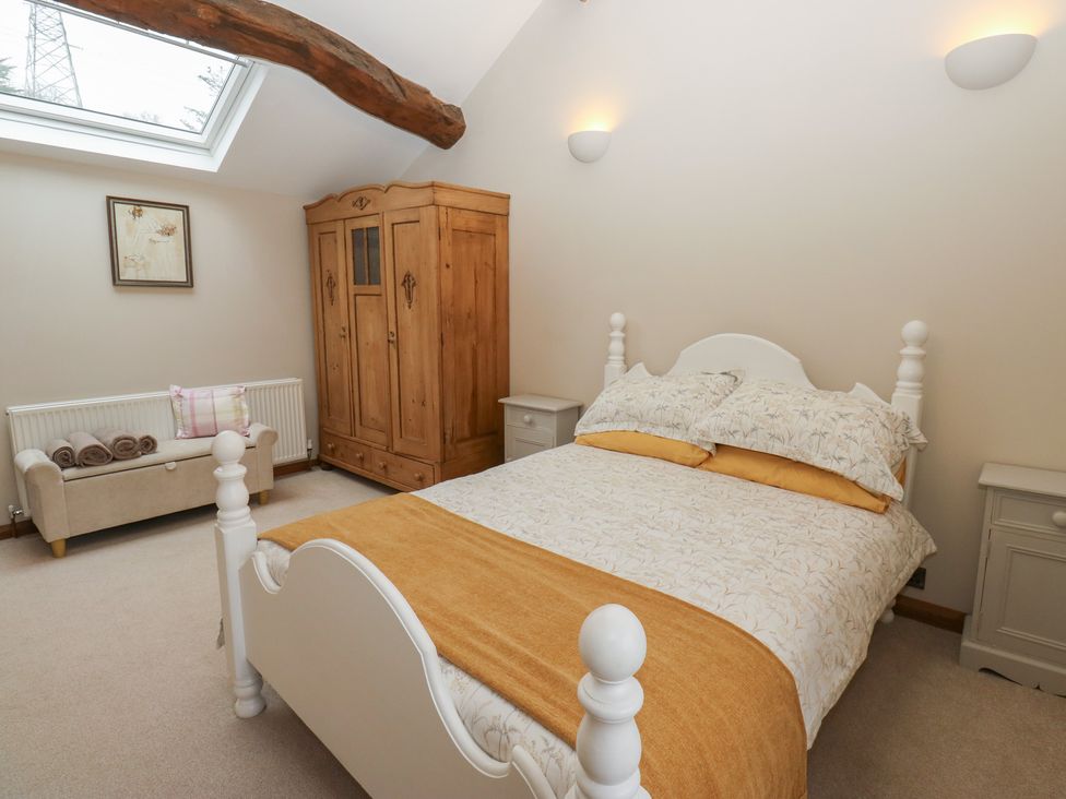 A bedroom with a bed and wardrobe at Barley Cote Farm in Riddlesden