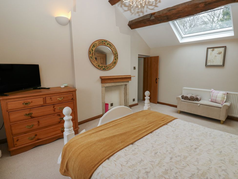 A bedroom with a bed and television at Barley Cote Farm in Riddlesden