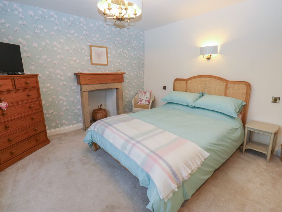 A bedroom with a bed and dresser at Barley Cote Farm in Riddlesden