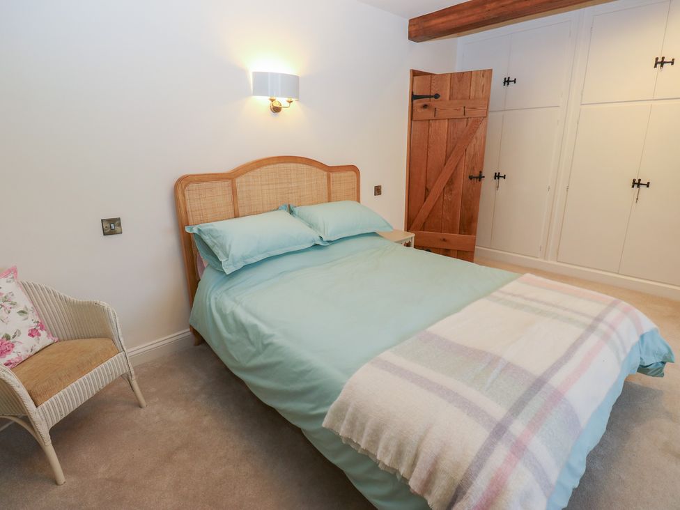 A bedroom with a bed and wardrobe at Barley Cote Farm in Riddlesden