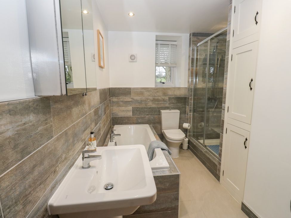 A bathroom with a bath tub, sink and toilet at Barley Cote Farm Riddlesden