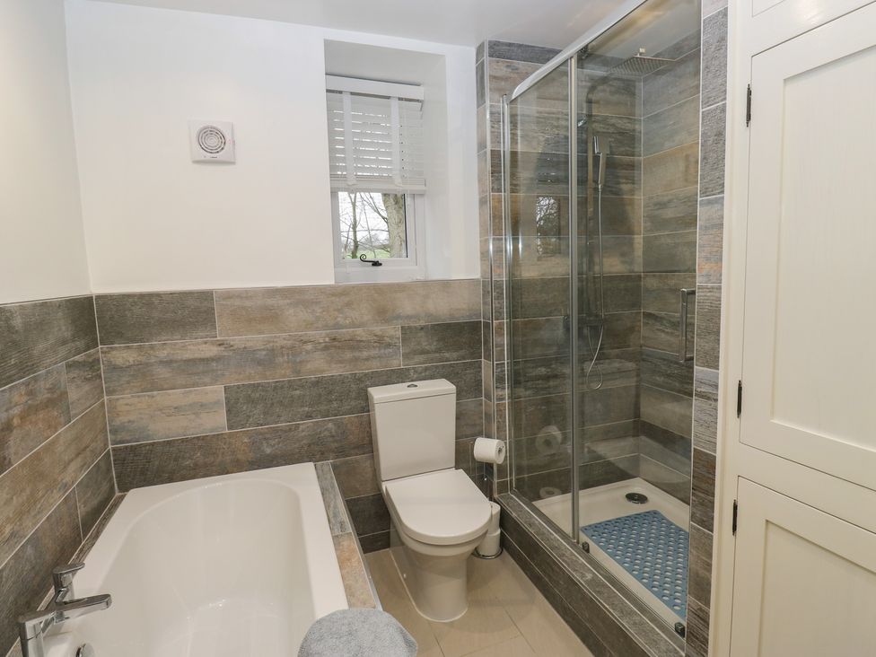 A bathroom featuring a bath tub and shower enclosure at Barley Cote Farm in Riddlesden