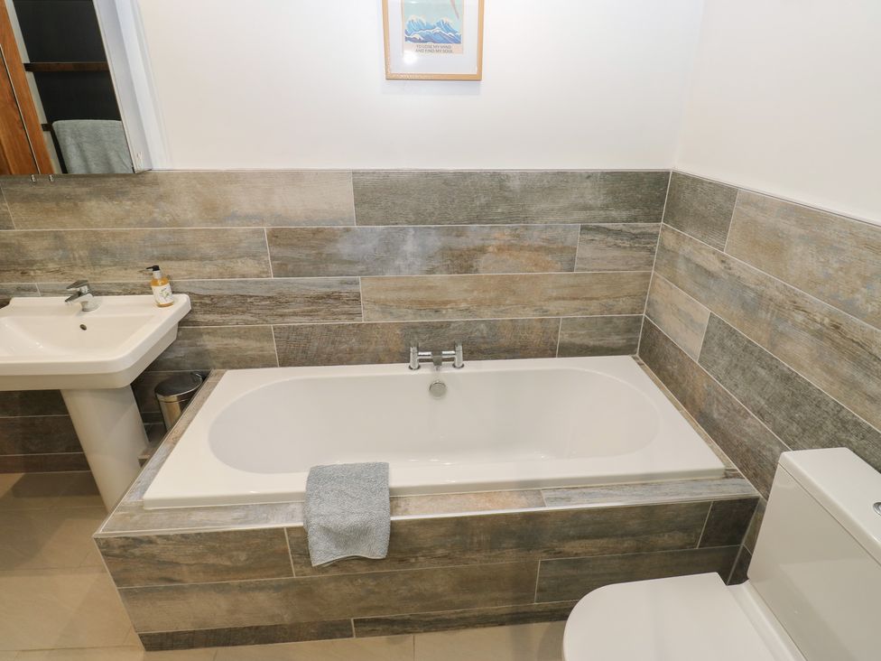 A bathroom with a bathtub and sink at Barley Cote Farm in Riddlesden