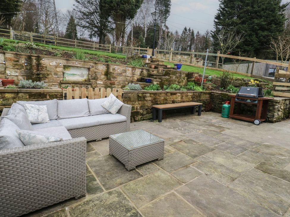 A garden with outdoor furniture and barbecue at Barley Cote Farm in Riddlesden