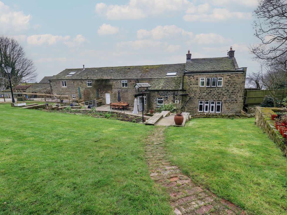 A garden with a pathway leading to a building at Barley Cote Farm in Riddlesden