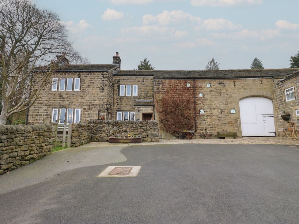 An outdoor view of a building with windows and a driveway at Barley Cote Farm in Riddlesden