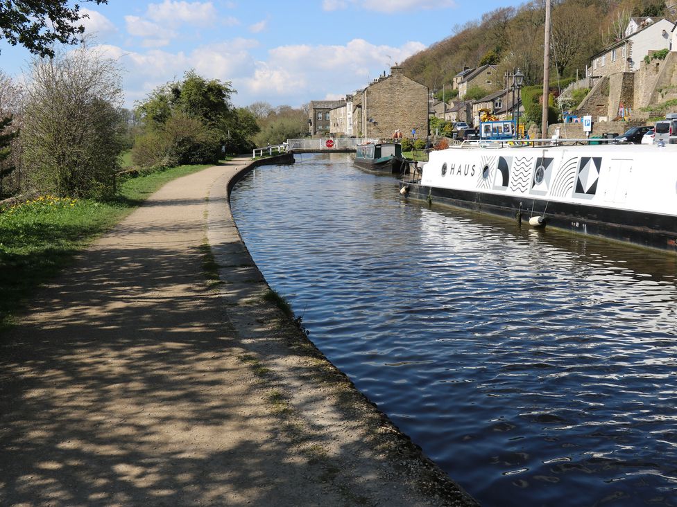 A canal with boats and a path at Barley Cote Farm in Riddlesden