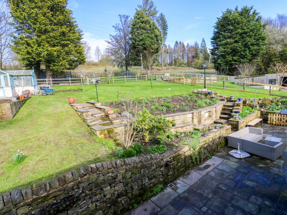 A garden with a seating area and plants at Barley Cote Farm in Riddlesden