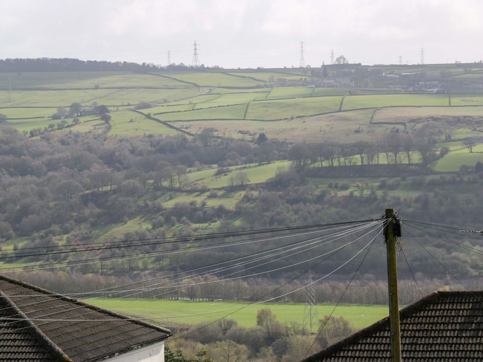 A view of hills and trees with electricity poles at Barley Cote Farm in Riddlesden