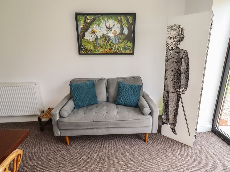 A living room with a sofa and artwork at Honeysuckle Cottage Crookham near Cornhill-On-Tweed