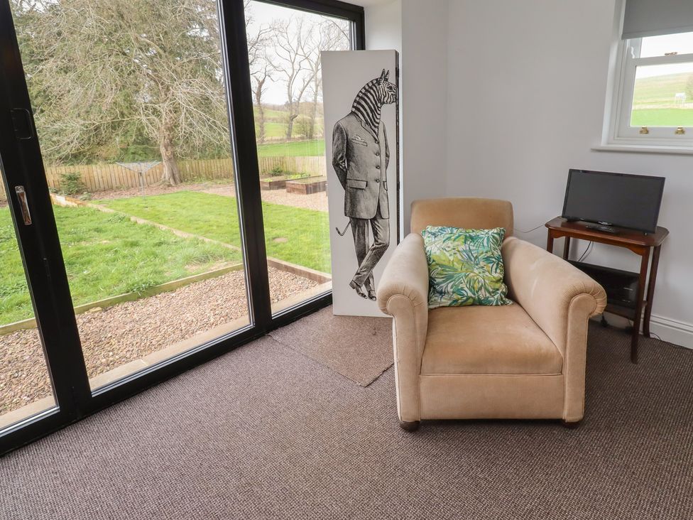 A snug with an armchair and zebra artwork at Honeysuckle Cottage in Crookham near Cornhill-On-Tweed