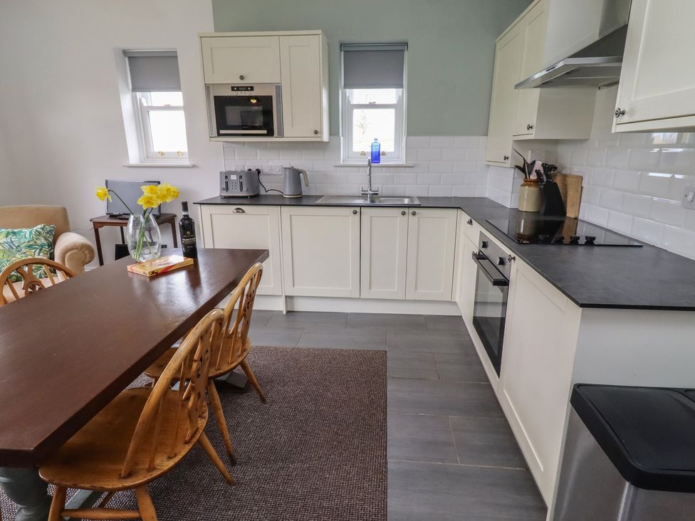 A kitchen with a dining table and chairs at Honeysuckle Cottage in Crookham near Cornhill-On-Tweed