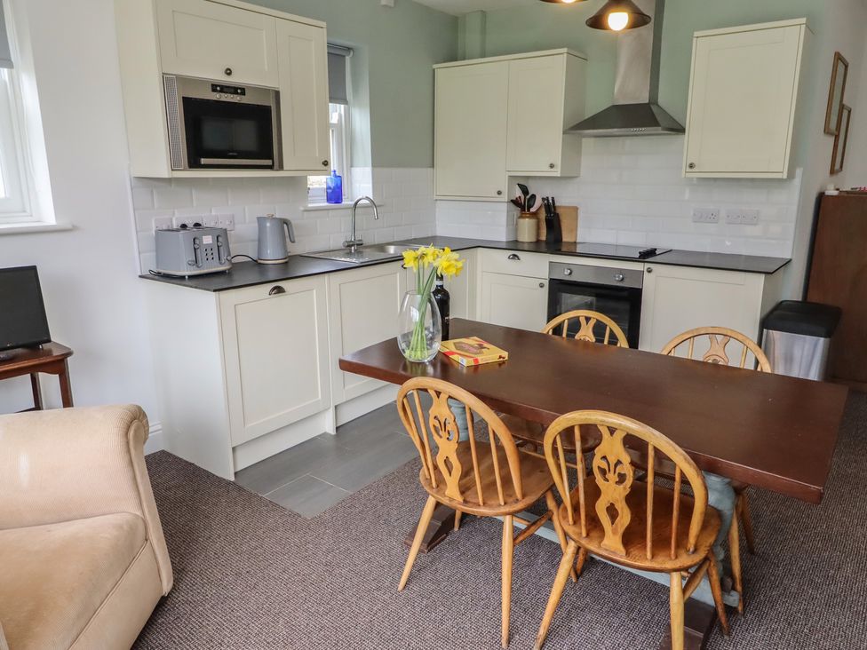A kitchen with a table and chairs at Honeysuckle Cottage in Crookham near Cornhill-On-Tweed