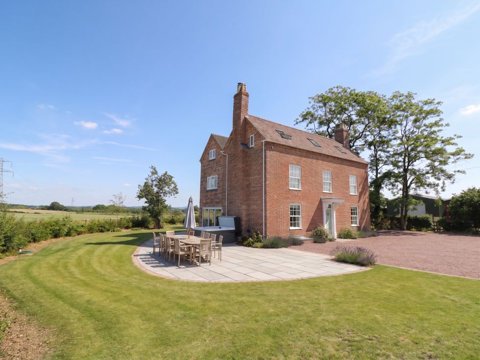 A house with a patio and dining table at Daniels Farmhouse in Claines