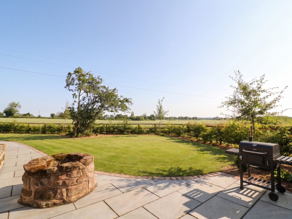A garden with a barbecue grill and fire pit at Daniels Farmhouse in Claines