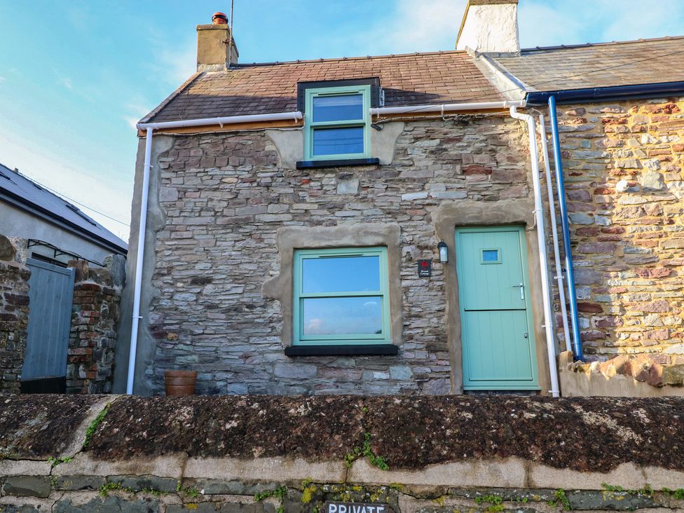 A stone cottage with windows and a door at 2 Strand Cottages Carmarthen