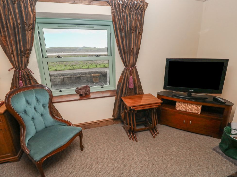 A living room with a window and a chair at 2 Strand Cottages in Carmarthen
