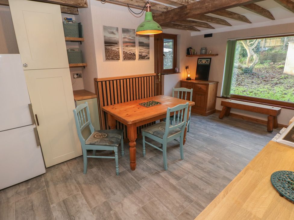 A dining room with a table and chairs at 2 Strand Cottages in Carmarthen