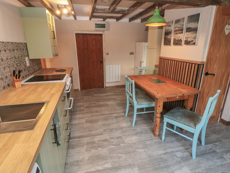 A kitchen with a dining table and chairs at 2 Strand Cottages in Carmarthen