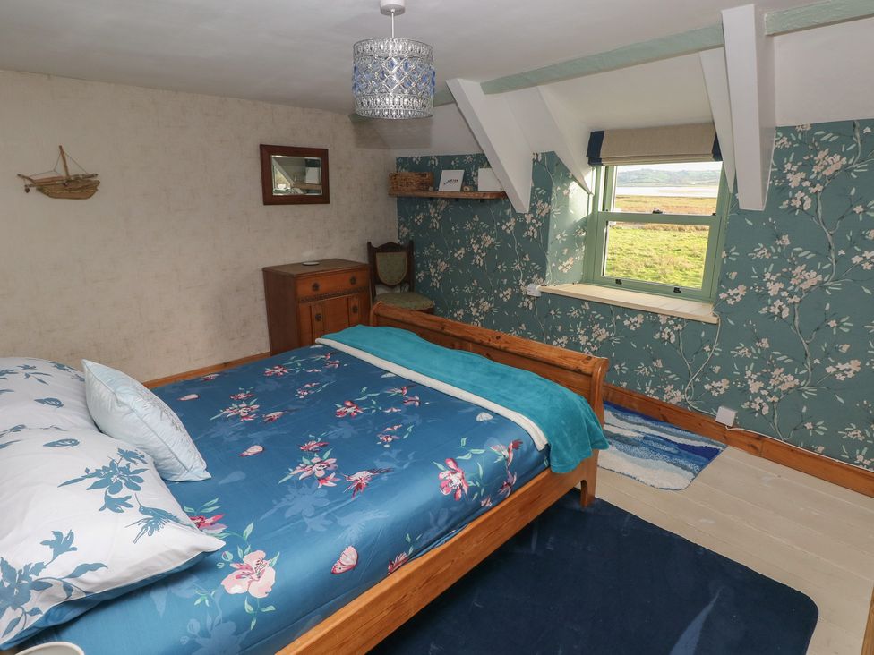 A bedroom with a bed and a chest of drawers at 2 Strand Cottages in Carmarthen