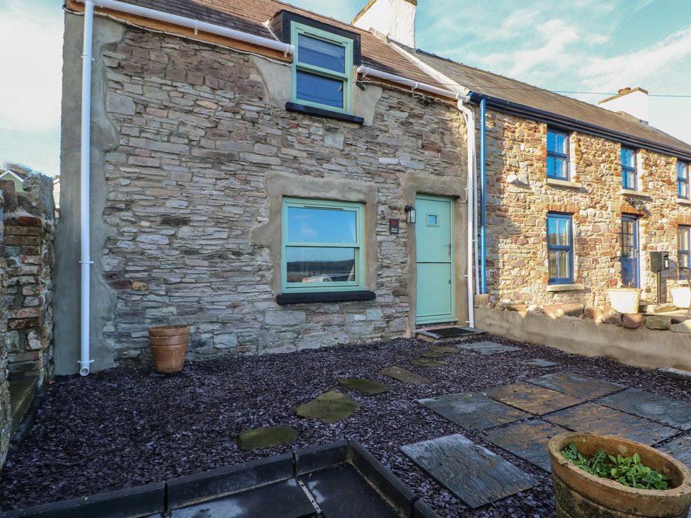 An outdoor area with stone wall and slate patio at 2 Strand Cottages in Carmarthen