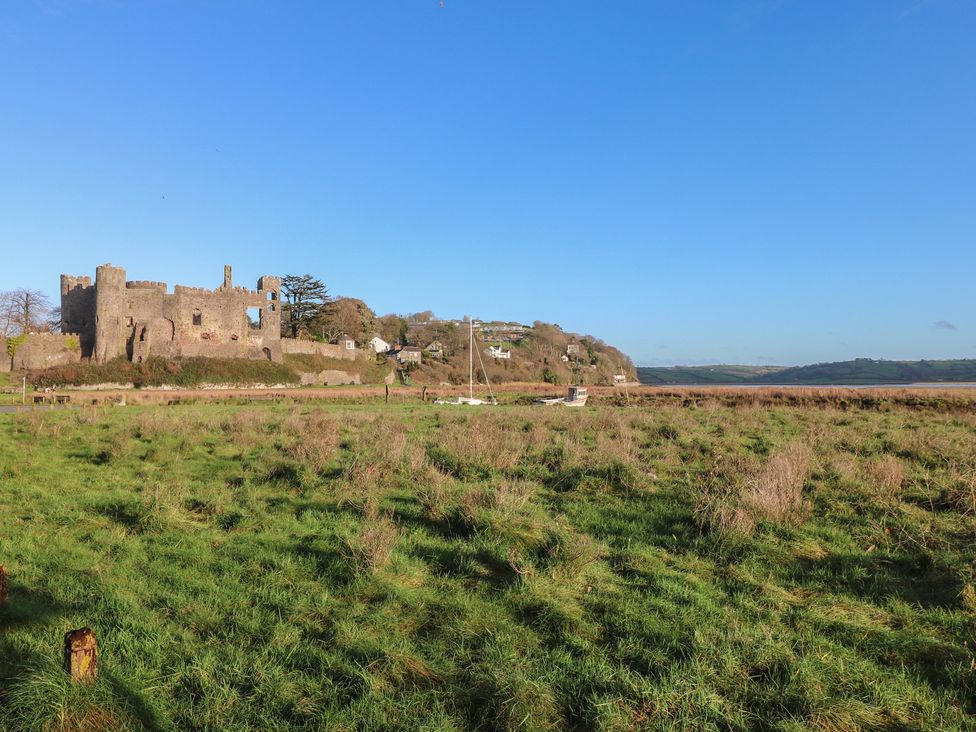 A view of a castle on a grassy area near the shore at 2 Strand Cottages in Carmarthen
